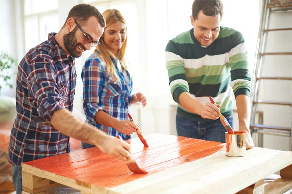 Young people painting furniture at home — Stock Photo, Image