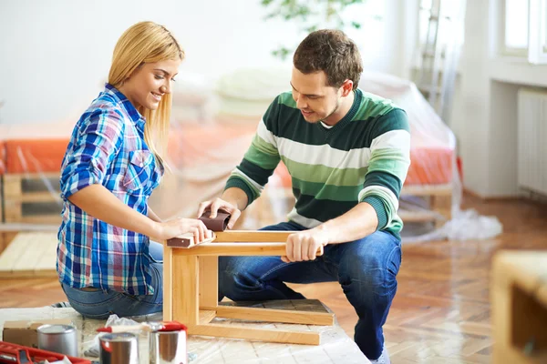 Young couple sanding furniture — Stock Photo, Image