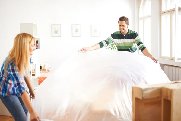 Couple covering furniture — Stock Photo, Image