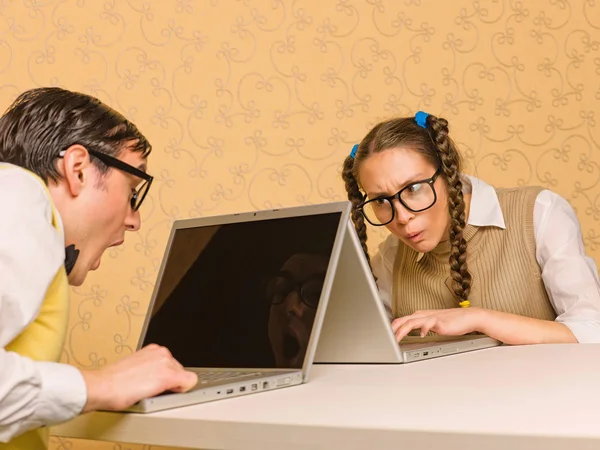 Jonge nerds zitten aan de balie met computers — Stockfoto