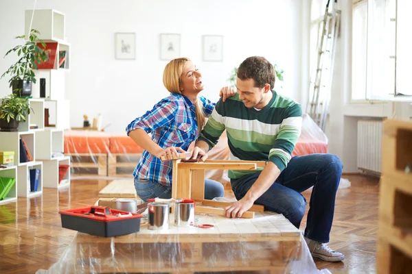 Young couple sanding furniture — Stock Photo, Image