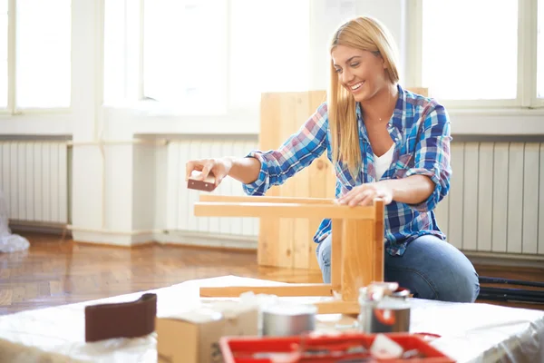 Woman sanding furniture — Stock Photo, Image