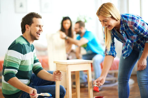Young couple painting furniture at home — Stock Photo, Image