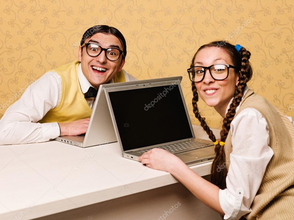 Young nerds sitting at the desk with computers