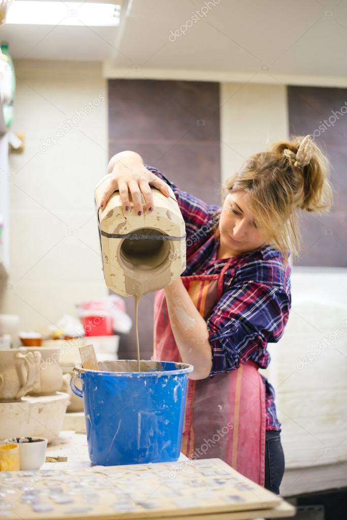 Pottery artist pouring clay