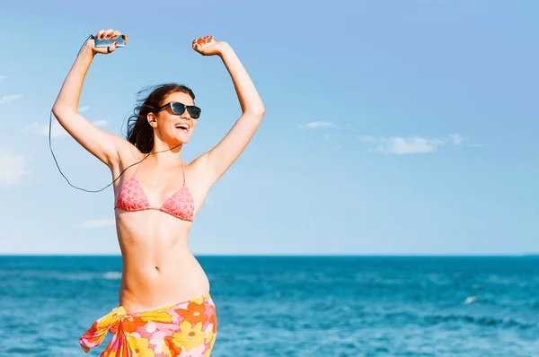 Vrouw genieten van muziek op strand — Stockfoto