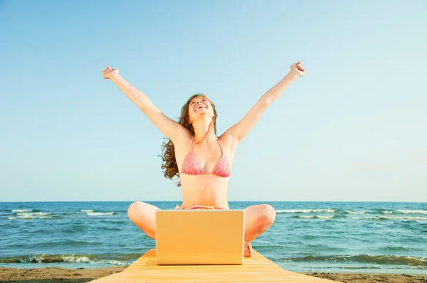 Femme à la plage avec ordinateur portable — Photo