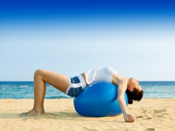 Woman doing pilates on beach — Stock Photo, Image