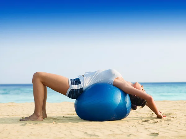 Žena, která dělá pilates na pláži — Stock fotografie