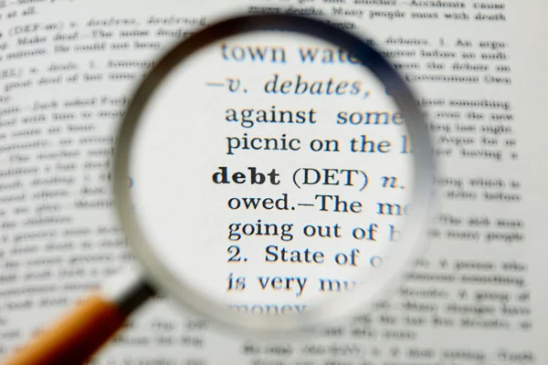 Een woordenboek en zakelijke definitie van een woord schuld — Stockfoto