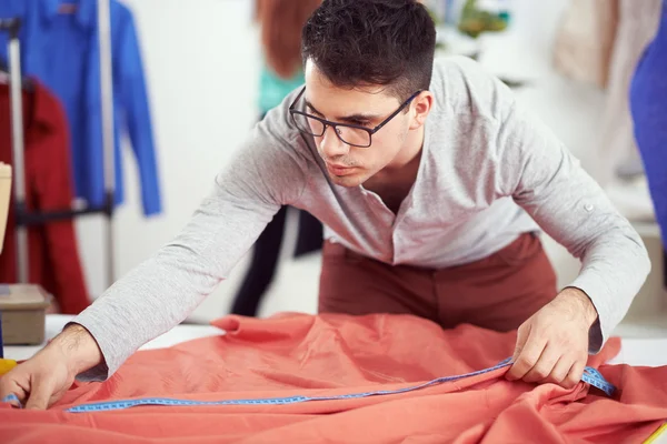 Designer measuring textile material — Stock Photo, Image