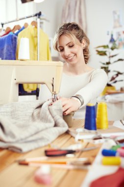 dikiş makinesi üzerinde çalışan tasarımcı