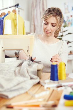dikiş makinesi üzerinde çalışan tasarımcı