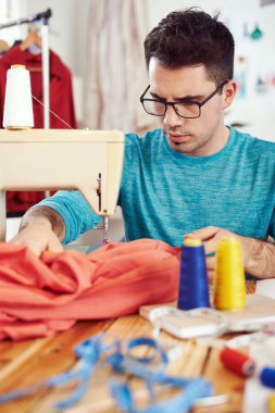 dikiş makinesi üzerinde çalışan tasarımcı