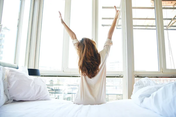 Woman stretching in bed — Stock Photo, Image