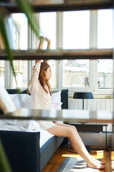 Frau dehnt sich im Bett — Stockfoto