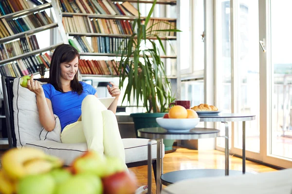 Mujer comer manzana y navegar por Internet — Foto de Stock