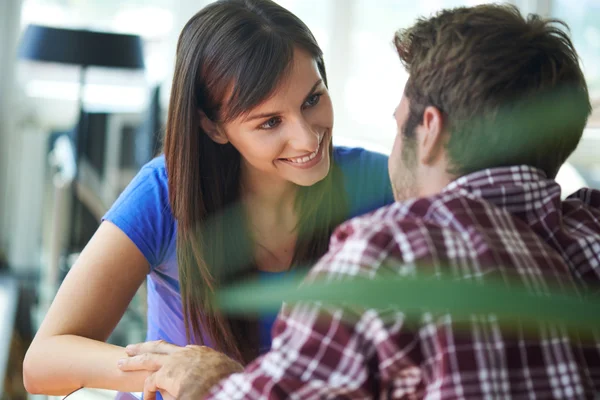 Coppia sorridente seduta in appartamento — Foto Stock