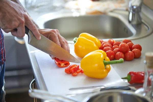 Mann schneidet Gemüse — Stockfoto