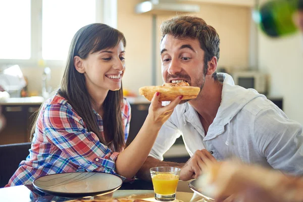 Mädchen füttert Kerl mit Stück Pizza — Stockfoto