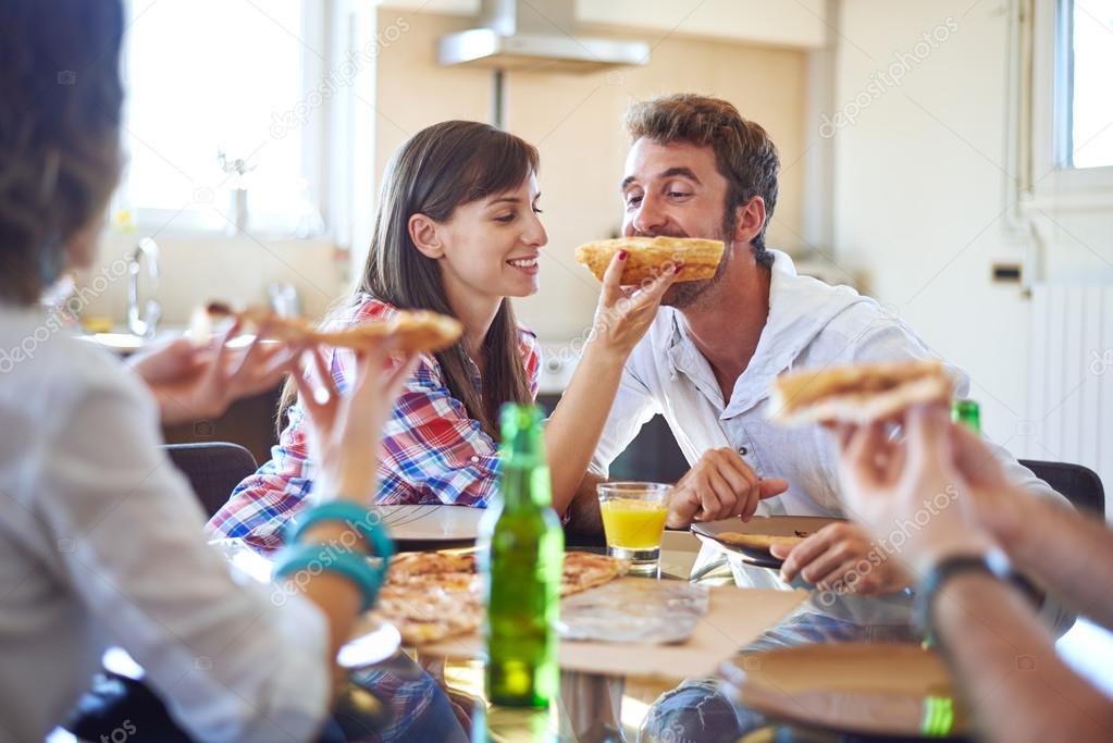 Two couples eating pizza