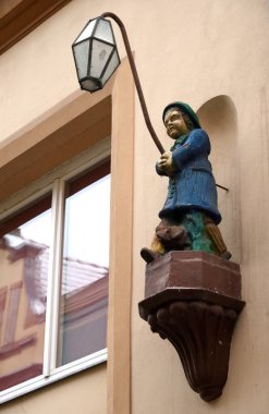 Sokak lambası, köpekli bir adamın ellerinde eski bir evde, Jelenia Gora, Polonya  