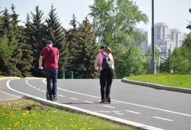 Genç kadın ve erkek, bahar, Moskova ve Rusya 'da Zafer Parkı' nda scooter kullanıyor.