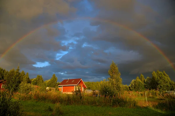Panorama of double rainbow over village in summer, Moscow region, Russia