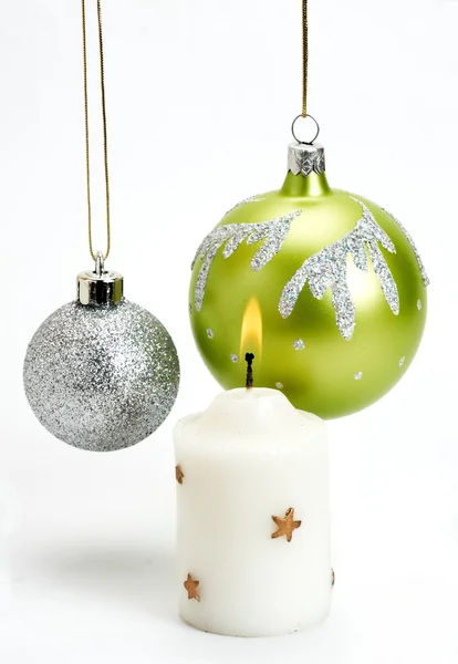 Baubles di Natale e candela su sfondo bianco — Foto Stock