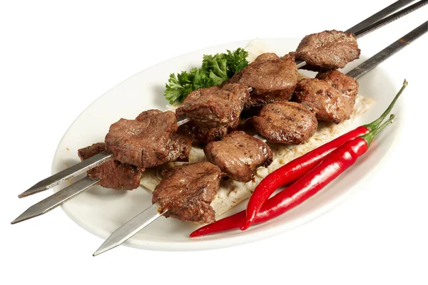 Maydanoz, kırmızı biber ve pasta beyaz plaka üzerinde şiş kebap