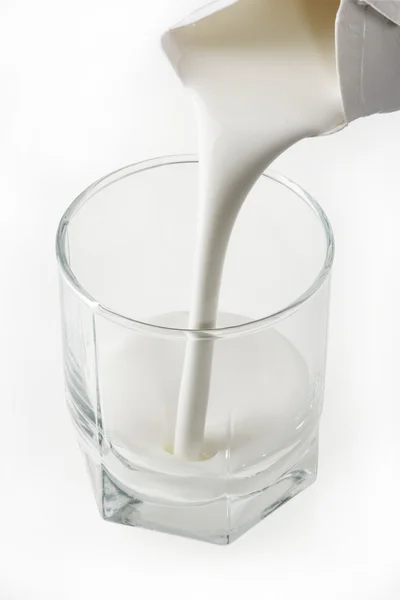 Verter un vaso de leche agria fresca — Foto de Stock