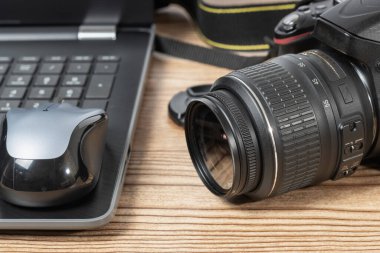 Masanın üzerinde DSR fotoğraf makinesi ve laptop var.