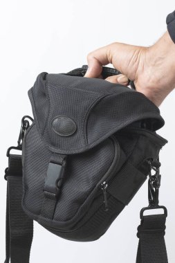 Elinde fotoğraf çantası var.