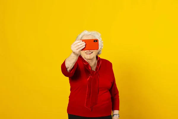 Studio Porträtt Äldre Kvinna Bär Röd Skjorta Mot Gul Bakgrund — Stockfoto