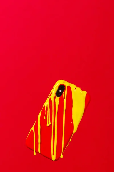 Żółty Obraz Topniejący Smartfonie Czerwoną Walizką Czerwonym Tle — Zdjęcie stockowe