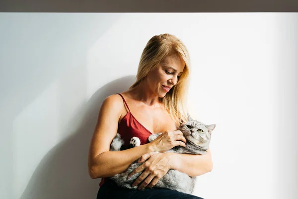Piękna Blondynka Średnim Wieku Siedzi Podłodze Swoim Kotem — Zdjęcie stockowe