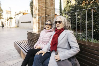 Son sınıf bayan arkadaşları birlikte gülerek dışarıda gündelik eğleniyorlar.