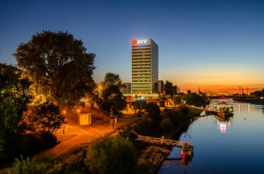 Mannheim, Almanya. 10 Ağustos 2012. Gün batımından sonra Neckar nehrinin manzarası. Arka planda MVV binası.