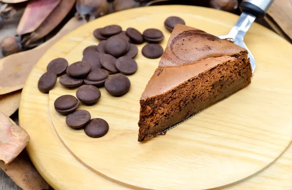 Bolo de chocolate escuro na placa de madeira — Fotografia de Stock