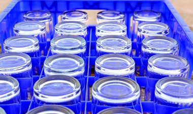 Boş su mavi plastik kutu içinde düzenlenmiş camlar