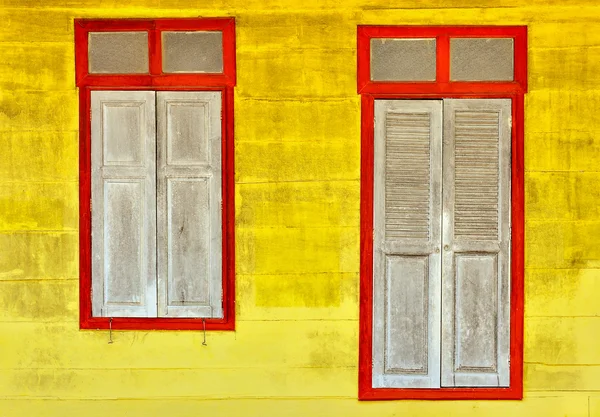 Old gray-red wooden door on yellow wooden wall — Stock Photo, Image