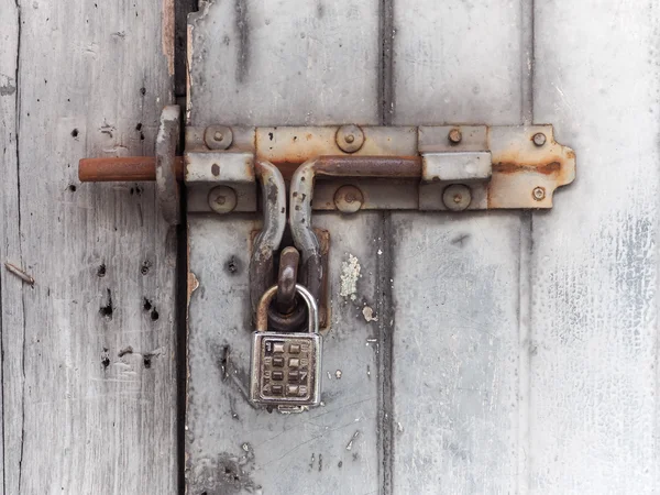 Old Padlock with key code on Wooden Gate