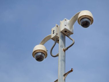 360 Derece Balık Gözlü Kubbe CCTV, mavi gökyüzüne karşı sütunlara monte edilmiştir. Güvenlik görüntüleme için CCTV
