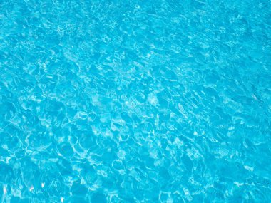 Yüzme havuzunda mavi dalgalı su. Su yüzeyinin arka plan görüntüsü.