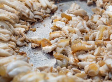 Fresh squid eggs with minced garlic on a hot pan. Popular seafood.