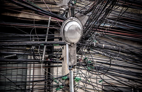 Pólo de lâmpada no emaranhado de fios elétricos fundo — Fotografia de Stock