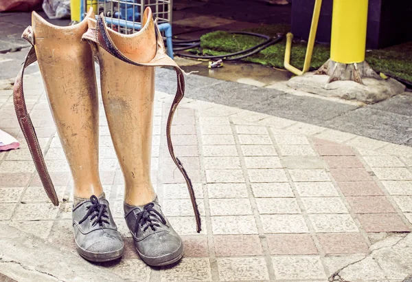 Old prosthetic legs set on a cement floor — Stock Photo, Image