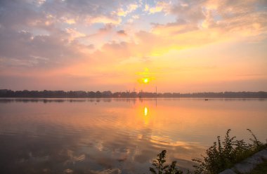 Sonbaharda bir gölün üzerinde gün doğumu sisle