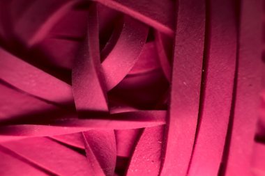 Pembe lastik bantlardan oluşan bir grubun yakın çekimi.