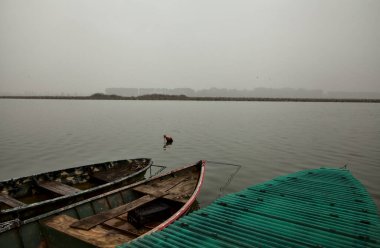 Sonbaharda sisli bir günde nehir kıyısında tekne.